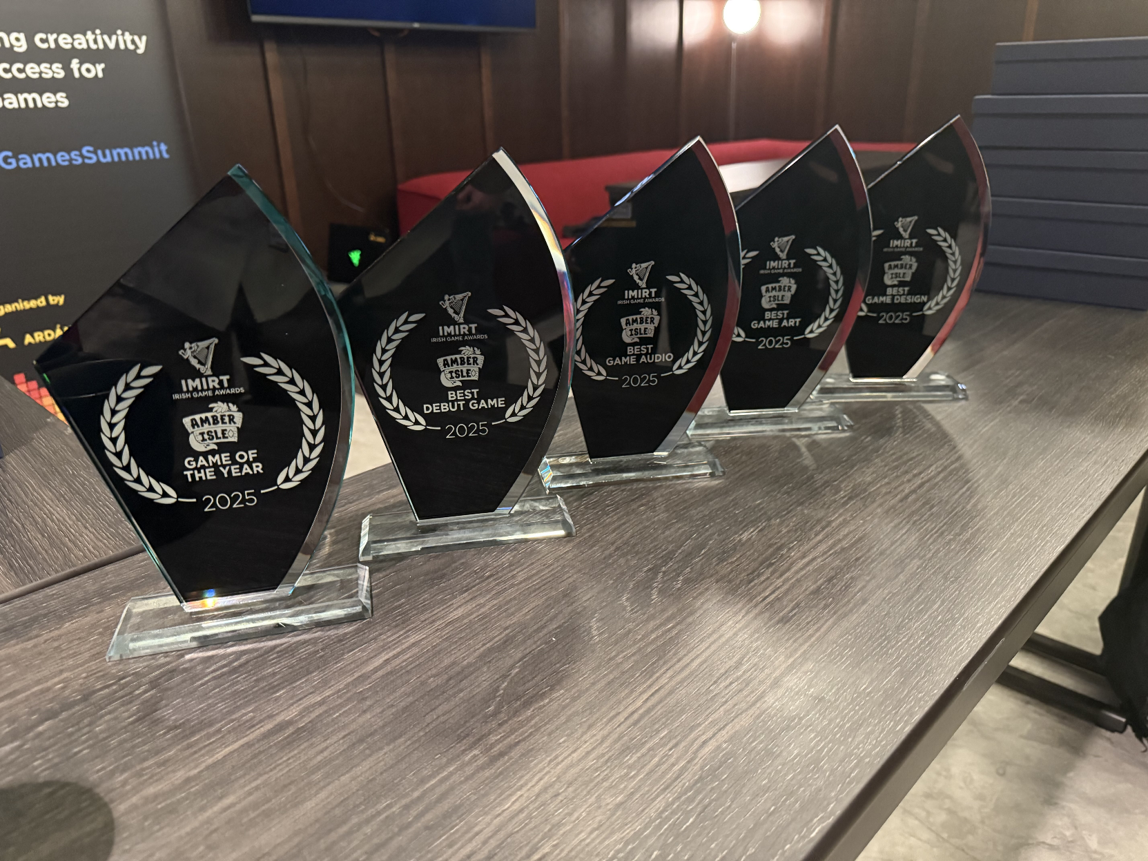 A photo of a line of 5 awards trophies for the 2025 IMIRT Irish Game Awards, for Game of the Year, Best Debut Game, Best Game Audio, Best Game Art, and Best Game Design.