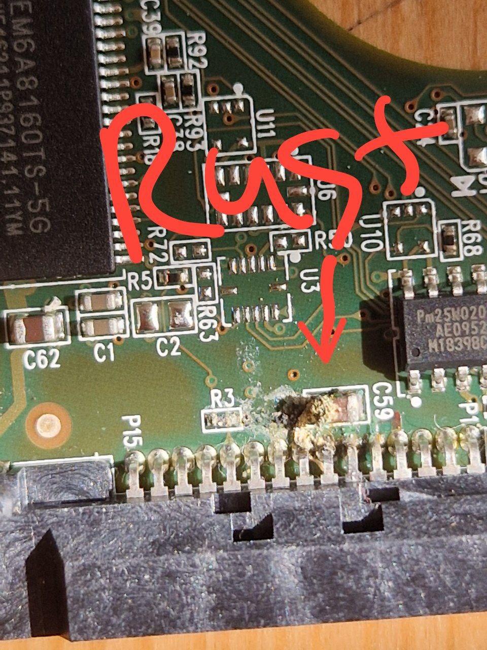 A photo of a printed circuit board, with some rust on it. There's a hand-drawn arrow that points to rust, and text "Rust"