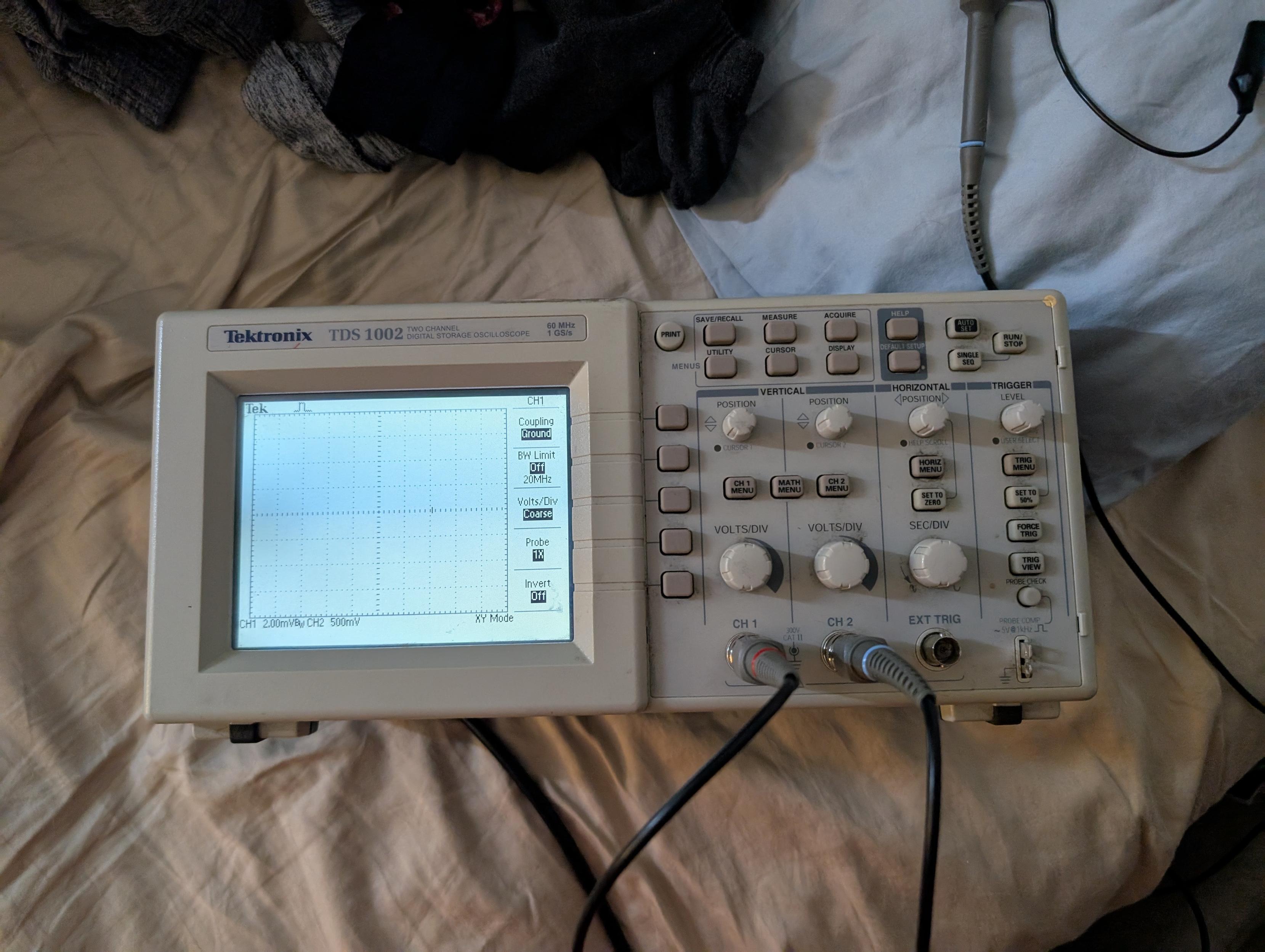 a Tektronix TDS-1002 on a bed with probes connected, showing no signal