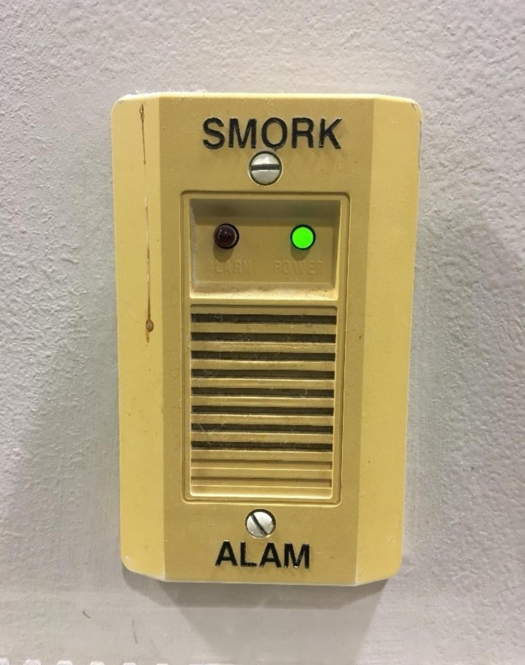 A smoke alarm labeled "SMORK ALAM"