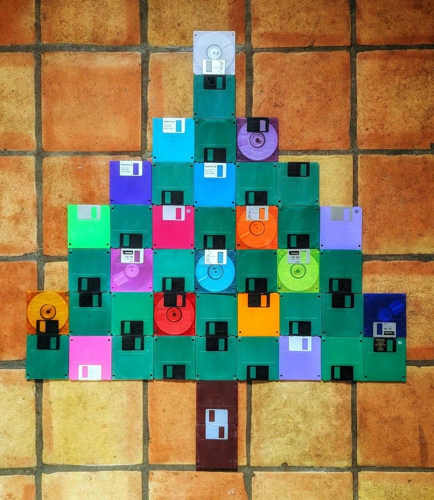 An artwork assembled from different colored 3.5 inch floppy disks shaped like a Xmas tree