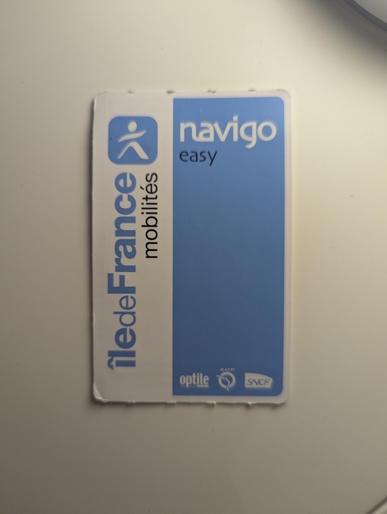 Bad picture of a navigo easy pass but made out of cardboard and rather bent on a corner. The blue color does not extend to the edges.

One can see it does not lie flat on the surface I put it on to take a picture.