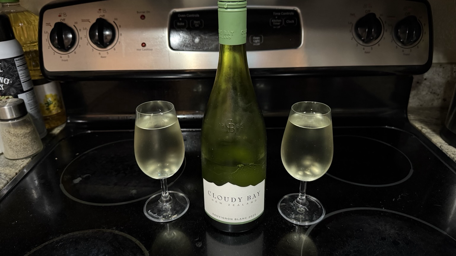 Bottle of “Cloudy Bay” Sauvignon blanc next to two poured glasses