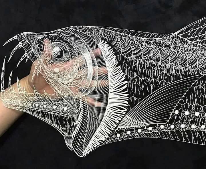 An incredibly intricate deep water fish with sharp teeth cut from paper.